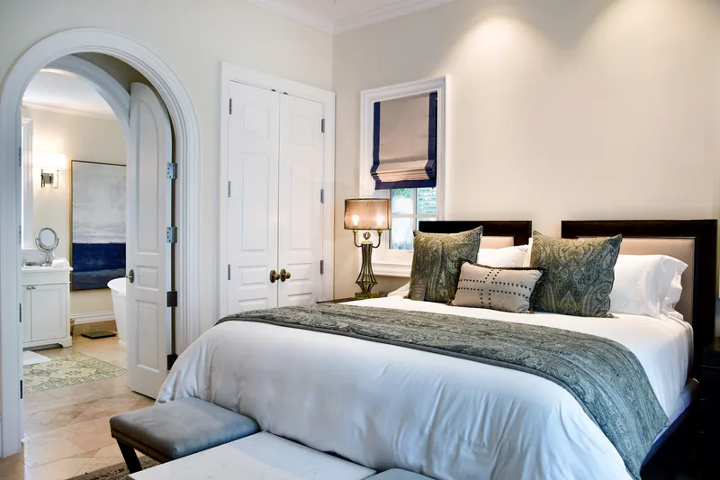 Une chambre d'amis au plaid gris et à la porte en arc
