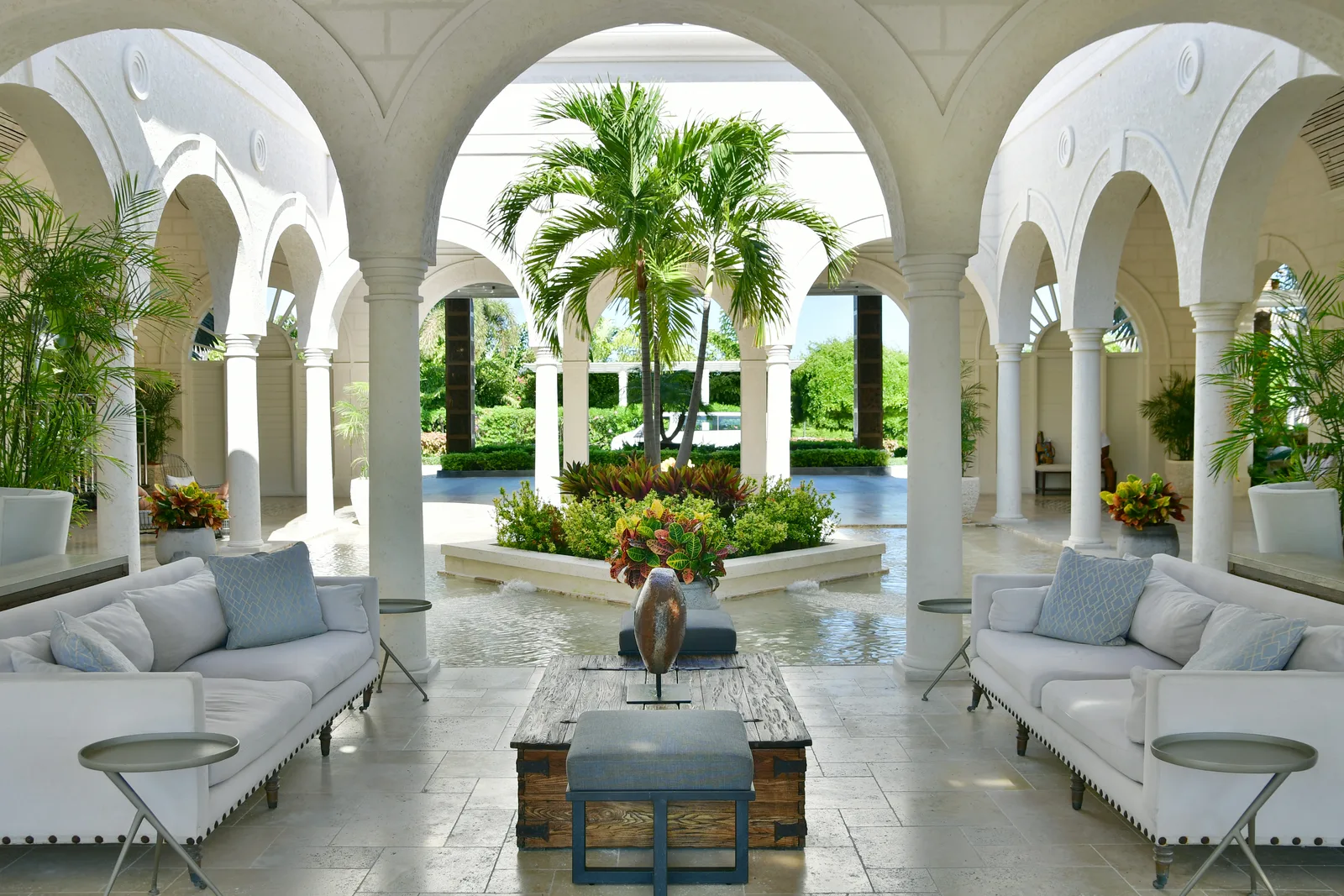 Un salon sous les arcades du resort, palmiers dans la cour