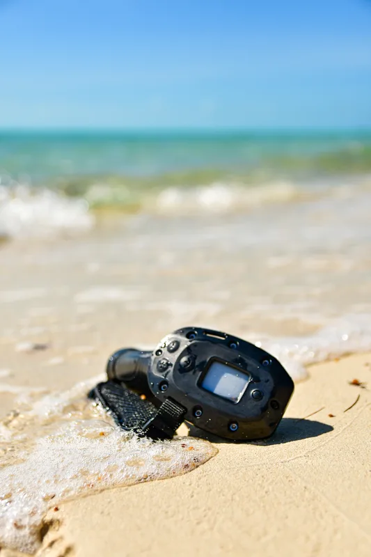 Une caméra d'action sur le sable, les vagues derrière
