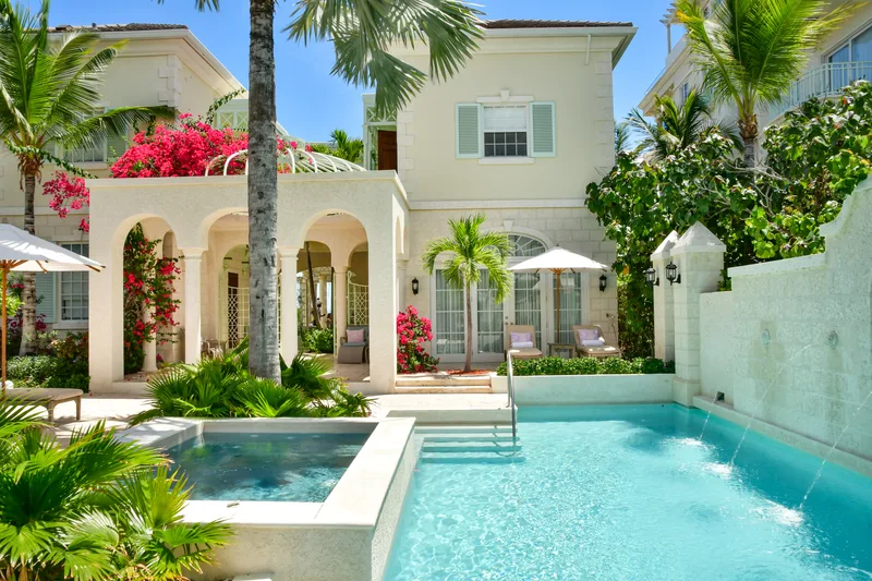 La piscine à débordement privée de Villa One, la maison et ses palmiers derrière